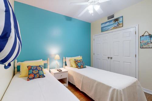 ein Schlafzimmer mit 2 Betten und einer blauen Wand in der Unterkunft Navy Cove Harbor 1306 in Gulf Shores