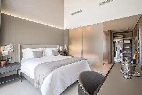 a bedroom with a large white bed and a chair at Suryaa Hotel Pinhais, Curio Collection by Hilton in Pinhais