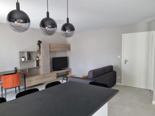 a living room with a table and a couch at LE MONTI appartement proche MEETT, Aéroport Blagnac, Airbus, Golf international de Seilh in Mondonville