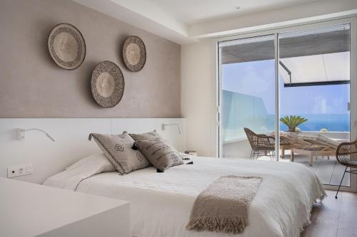 biała sypialnia z dużym łóżkiem i stołem w obiekcie Infinity Horizon Apartment - Costa Blanca w mieście Cumbre del Sol