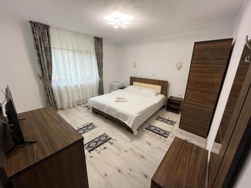 a bedroom with a bed and a dresser in it at Casa Marci Teo in Moieciu de Jos