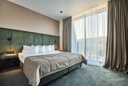 a bedroom with a large bed and a large window at Fomich Residence in Bukovel