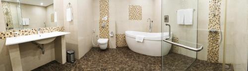 Premier Hotel في المنامة: حمام مع حوض ومغسلة ومرحاض