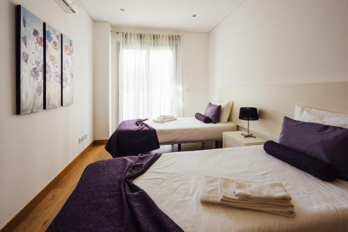 1 dormitorio con 2 camas y ventana en Clerigo - Holiday Apartments - By SCH, en São Martinho do Porto