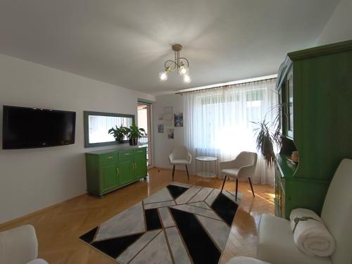 uma sala de estar com televisão e um armário verde em Relax Apartment Suwałki em Suwałki