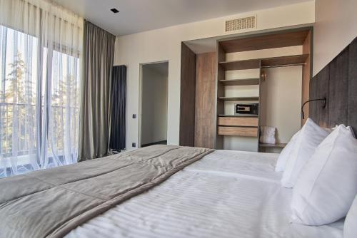 a bedroom with a large bed and a large window at Fomich Residence in Bukovel