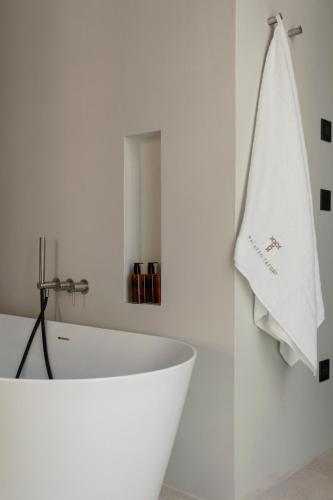 a white bathroom with a bath tub and a towel at Palazzo Tafuri Boutique Hotel in Nardò