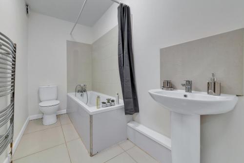 uma casa de banho branca com um lavatório e um WC em Suites by Rehoboth - Makeba Suite - Dartford em Dartford
