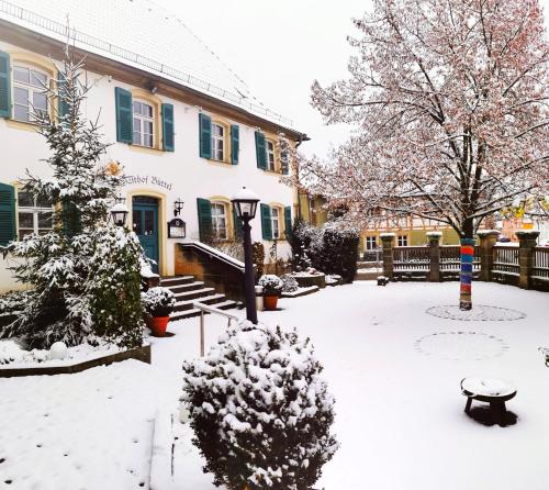 a yard covered in snow in front of a house at Landgasthof Büttel in Geisfeld