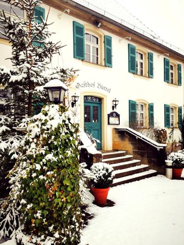 a building with a blue door in the snow at Landgasthof Büttel in Geisfeld