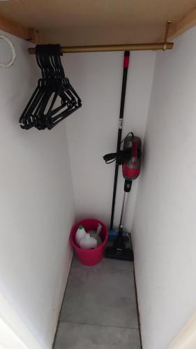 a corner of a room with a broom and a red bucket at Portillo in Puy-Saint-Vincent