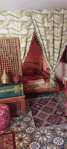 ムーレイ・イドリスにあるRiad lala zakiaのベッド1台、椅子2脚、ラグ1枚が備わる客室です。