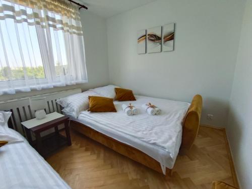 two stuffed animals sitting on a bed in a room at Relax Apartment Suwałki in Suwałki