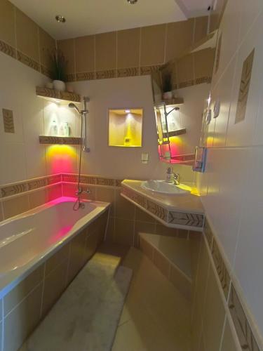 a bathroom with two sinks and a bath tub at Relax Apartment Suwałki in Suwałki