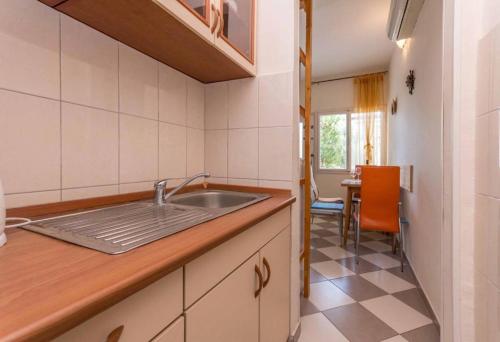 a kitchen with a sink and a table at Neptun apartments in Pirovac
