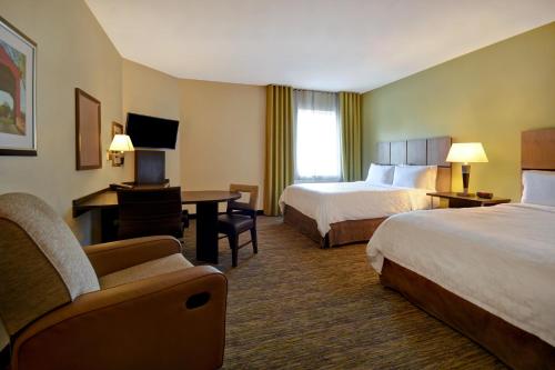 a hotel room with two beds and a desk at Candlewood Suites Carrollton, an IHG Hotel in Carrollton
