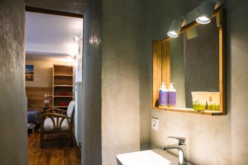 une salle de bain avec un lavabo et un miroir dans l'établissement Les chambres de la Dourbie, à Nant