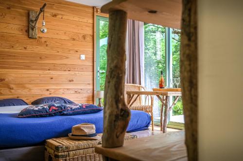 - une chambre avec un lit avec des draps bleus et une table dans l'établissement Les chambres de la Dourbie, à Nant