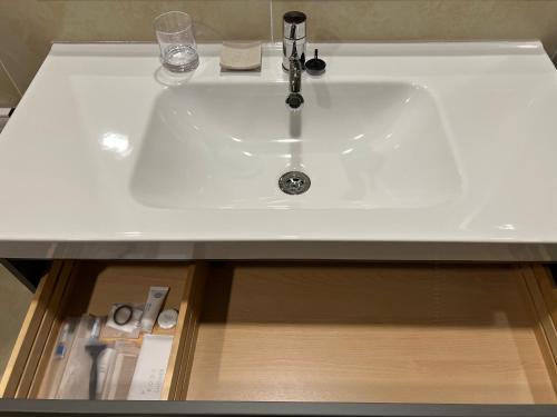 a white sink in a bathroom with a drawer at Jinhae Intercity Hotel in Changwon