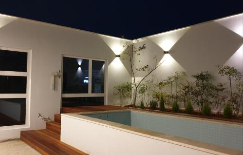 uma casa com piscina com plantas na parede em Jinhae Intercity Hotel em Changwon