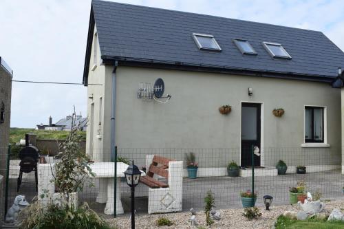 a white house with a black roof at Cosy two bedroom cottage on the Mullet Peninsula in Ballina