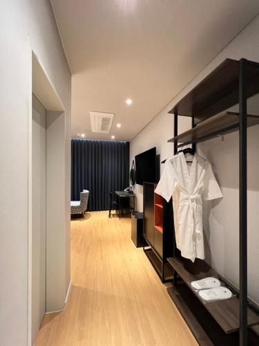 una camera con armadio e camicia su una mensola di Jinhae Intercity Hotel a Changwon