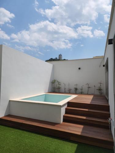 a swimming pool on a deck with a house at Jinhae Intercity Hotel in Changwon