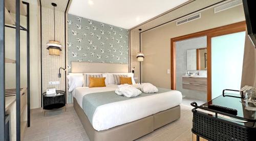 a bedroom with a large bed and a bathroom at Soho Boutique Columela in Cádiz