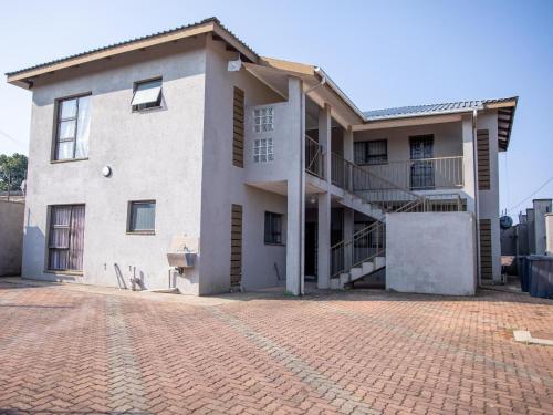 dom z ceglanym podjazdem przed nim w obiekcie Ekasi Apartments w mieście Mbabane