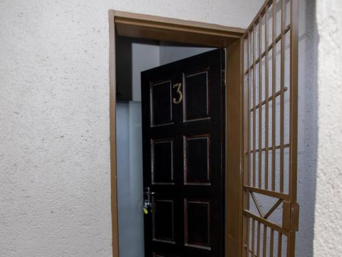 una porta aperta che conduce a una stanza con parete bianca di Ekasi Apartments a Mbabane