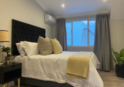 een slaapkamer met een bed en een groot raam bij The Loft on Monteith in Durban