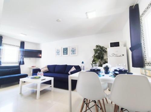 ein Wohnzimmer mit einem blauen Sofa und einem Tisch in der Unterkunft Marbella Center Apartment in Marbella