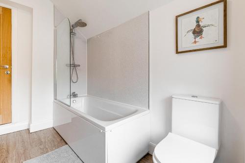 een witte badkamer met een toilet en een wastafel bij Silver Stag Properties, Cozy 2 BR House w Garden in Donisthorpe