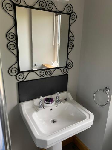 bagno con lavandino bianco e specchio di Wee Kirkhill a Perth
