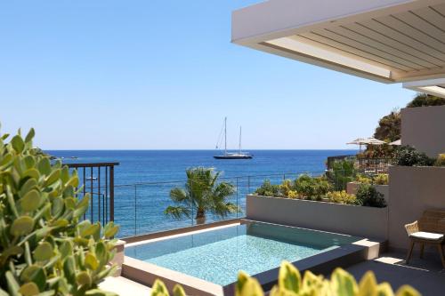 a swimming pool with a view of the ocean at Castello Infinity Suites - Adults Only in Agia Pelagia