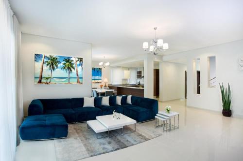 a living room with a blue couch and a table at The Grove Resort Bahrain in Manama