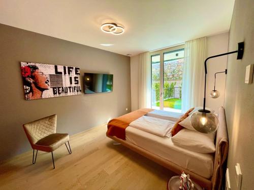 a bedroom with a bed and a chair and a window at IL SOGNO al Lago di Garda in Torri del Benaco