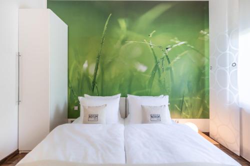 two white beds in a room with a green wall at Hotel Freiraum in Mönchengladbach