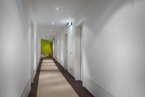 a hallway with white walls and a green wall at Hotel Freiraum in Mönchengladbach