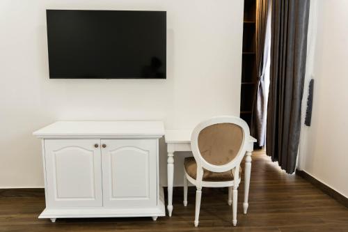 a white desk with a chair and a tv at Henry Crown Hotel in Thôn Trường Giang