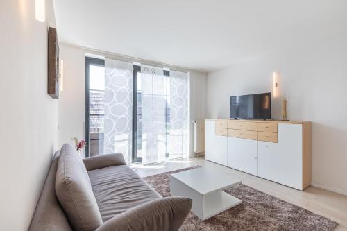 a living room with a couch and a tv at Hotel Freiraum in Mönchengladbach