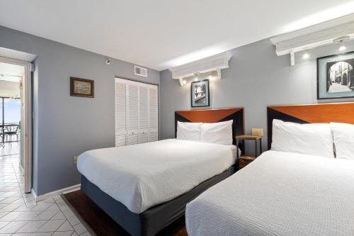 a hotel room with two beds and a balcony at Spectacular Oceanfront Condo in Myrtle Beach