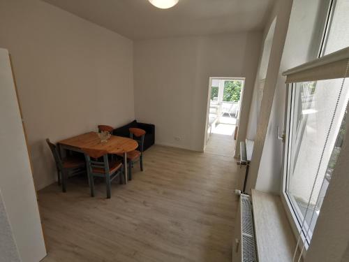 comedor con mesa de madera y sillas en Ferdimesse Apartments, en Colonia