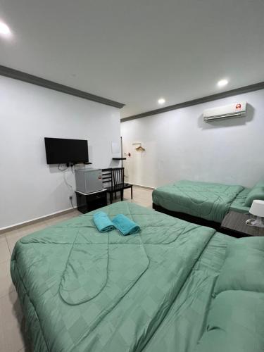 a bedroom with two beds and a flat screen tv at Ourstay Nadi Kota in Bandar  Pusat Jengka
