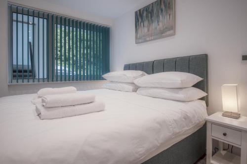a bedroom with a white bed with white pillows at Beach Court - 1 Bedroom Apartment - Saundersfoot in Saundersfoot