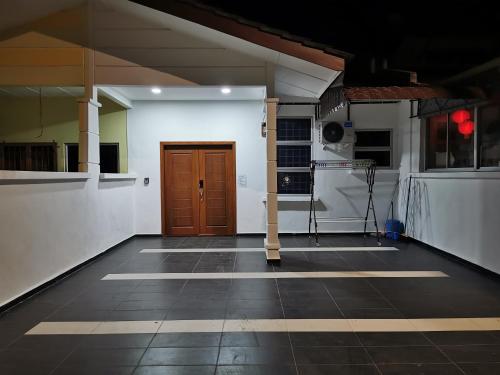 an empty room with a wooden door in a building at SinggahSini Homestay Melaka in Kampong Gelam