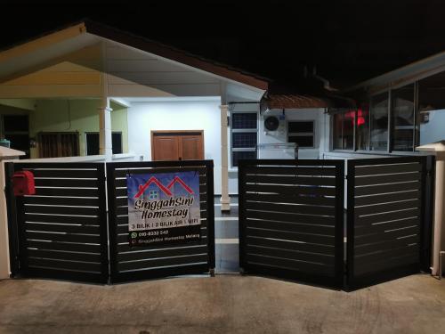 a garage door with a sign in front of it at SinggahSini Homestay Melaka in Kampong Gelam