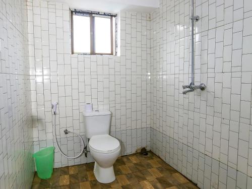 a white bathroom with a toilet and a window at Arusha Safari Hostel in Arusha
