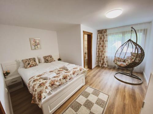 a bedroom with a bed and a hanging basket at Casa cu vitralii in Slănic-Moldova