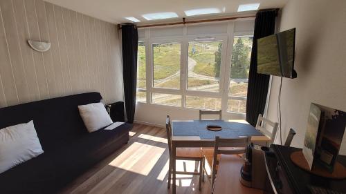 a living room with a couch and a table at Le Portillo in Puy-Saint-Vincent